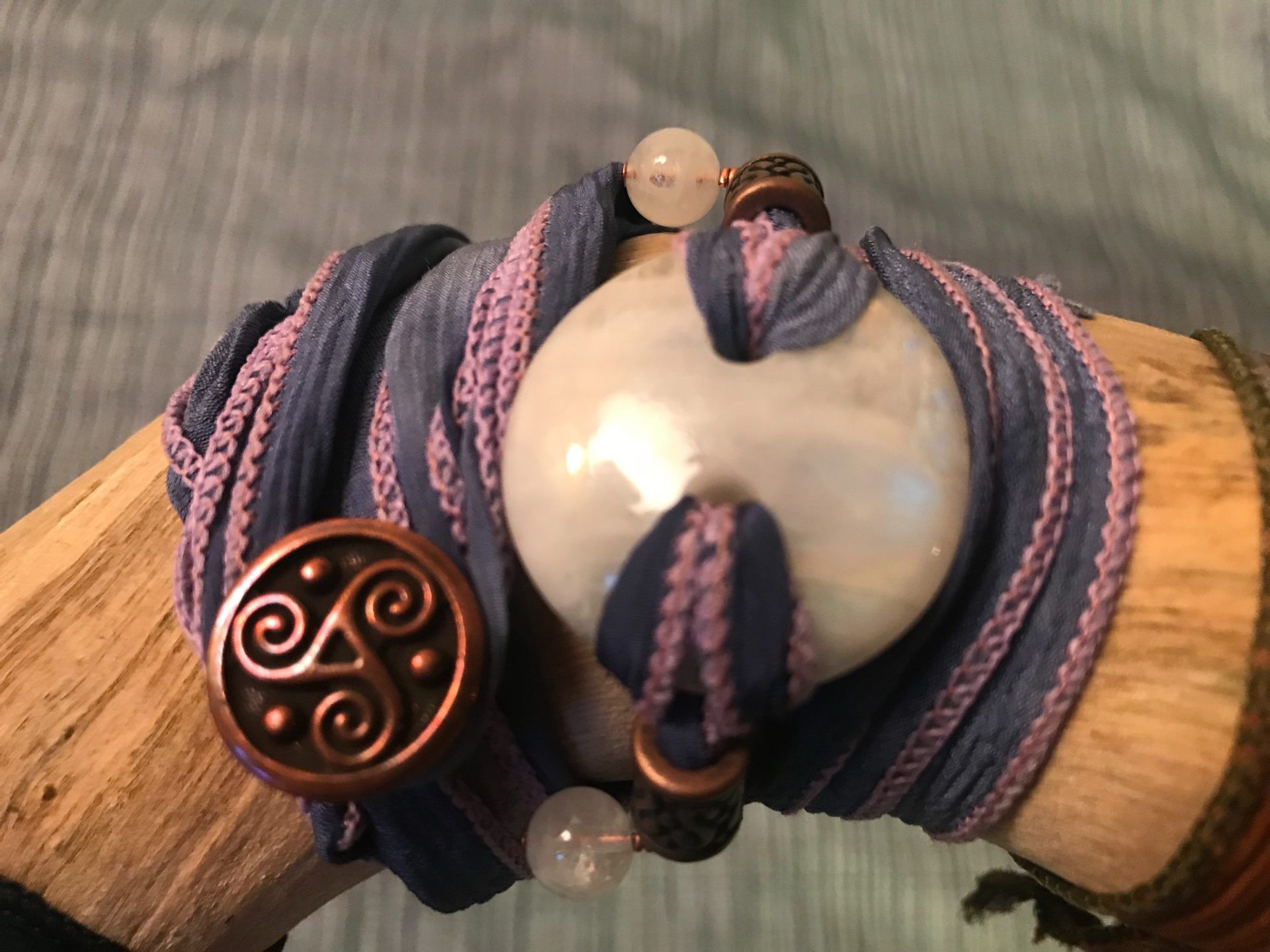 #37 WRIST WRAP ($75): Rainbow Moonstone, Copper Tibetan Beads, Triskelion Charm, Gray-Blue Silk Ribbon